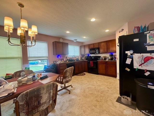 6460 Woodcreek Dr, Middletown, OH 45042 - kitchen featuring black appliances, a chandelier, recessed lighting, brown cabinets, and pendant lighting