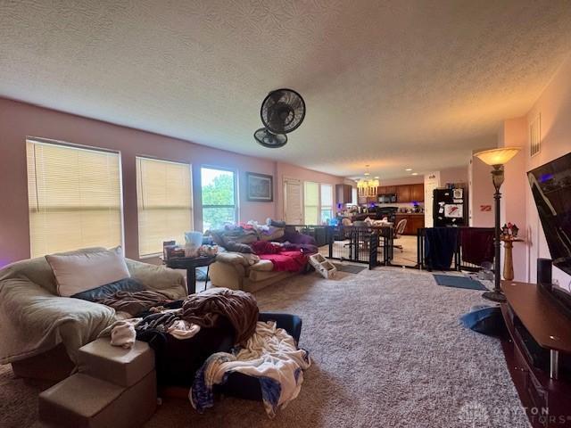 6460 Woodcreek Dr, Middletown, OH 45042 - living room featuring a chandelier, carpet floors, and a textured ceiling