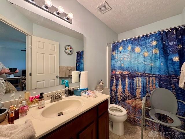 6460 Woodcreek Dr, Middletown, OH 45042 - bathroom with vanity, tile patterned floors, a textured ceiling, and curtained shower