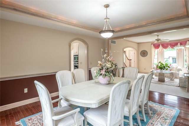 337 Yorkshire Ln, Beavercreek Twp, OH 45385 - dining space featuring arched walkways, hardwood / wood-style floors, a tray ceiling, and a ceiling fan