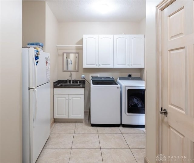 337 Yorkshire Ln, Beavercreek Twp, OH 45385 - laundry area featuring washing machine and clothes dryer, light tile patterned floors, and cabinet space