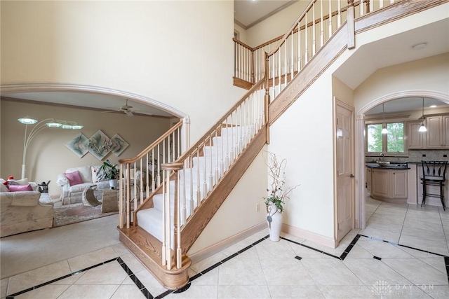 337 Yorkshire Ln, Beavercreek Twp, OH 45385 - stairway with tile patterned floors, ceiling fan, inlaid floor details, and a high ceiling