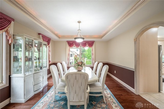 337 Yorkshire Ln, Beavercreek Twp, OH 45385 - dining area featuring a tray ceiling, arched walkways, and wood finished floors