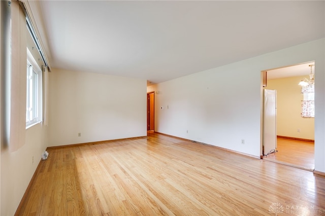 8866 Meadowlark Dr, Franklin, OH 45005 - spare room featuring light wood-style floors, a chandelier, and plenty of natural light