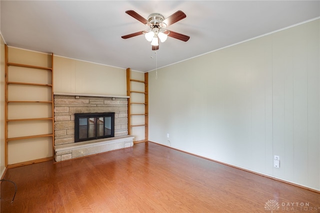 8866 Meadowlark Dr, Franklin, OH 45005 - unfurnished living room featuring wood finished floors, a stone fireplace, ceiling fan, and ornamental molding