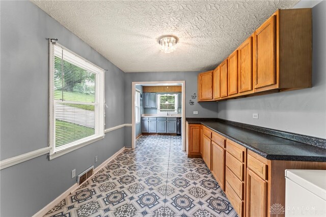 405 Hyde Park Dr, Hamilton, OH 45013 - kitchen with dark countertops, brown cabinets, and a textured ceiling