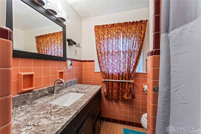 405 Hyde Park Dr, Hamilton, OH 45013 - bathroom with tile walls, tile patterned floors, vanity, a wainscoted wall, and a textured ceiling