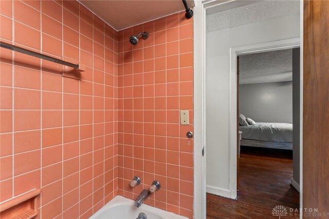 405 Hyde Park Dr, Hamilton, OH 45013 - ensuite bathroom featuring wood finished floors, shower / bathtub combination, and a textured ceiling