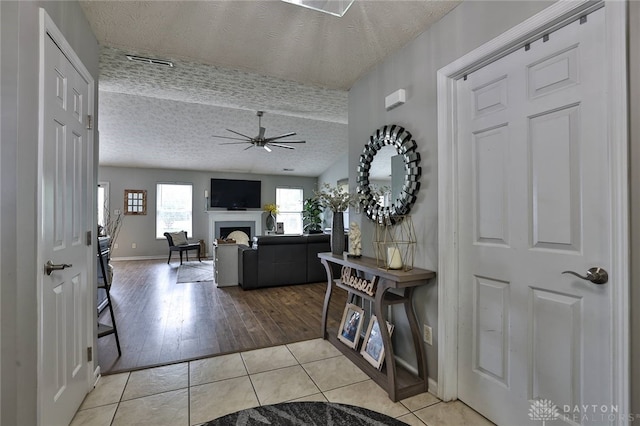 11 Green Meadow Ct, Franklin, OH 45005 - foyer featuring a textured ceiling, tile patterned floors, a ceiling fan, and a fireplace