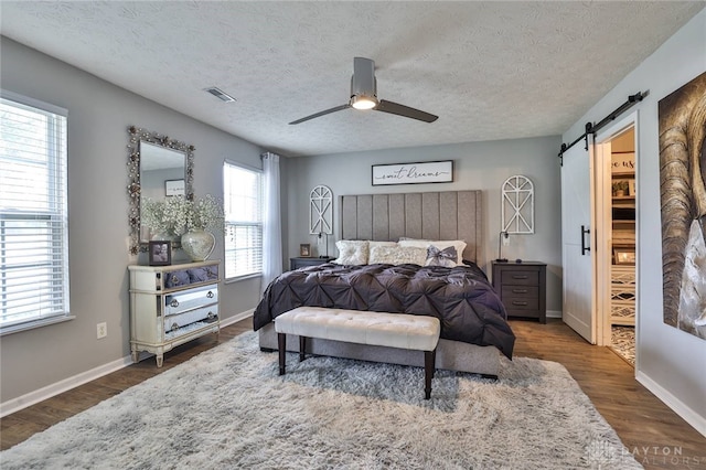 11 Green Meadow Ct, Franklin, OH 45005 - bedroom with a barn door, a textured ceiling, dark wood-type flooring, and ceiling fan