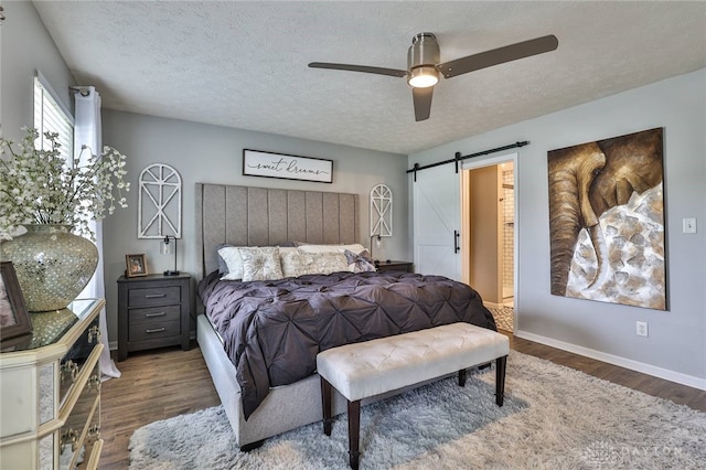 11 Green Meadow Ct, Franklin, OH 45005 - bedroom featuring a barn door, wood finished floors, a textured ceiling, and a ceiling fan