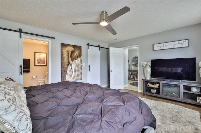 11 Green Meadow Ct, Franklin, OH 45005 - bedroom featuring a barn door, wood finished floors, connected bathroom, a textured ceiling, and ceiling fan