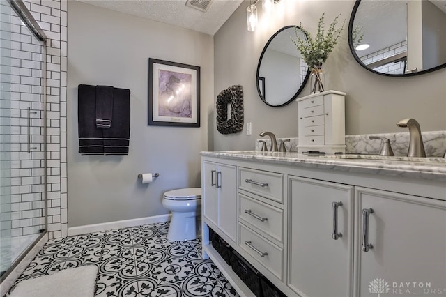 11 Green Meadow Ct, Franklin, OH 45005 - bathroom featuring tiled shower, double vanity, and a textured ceiling