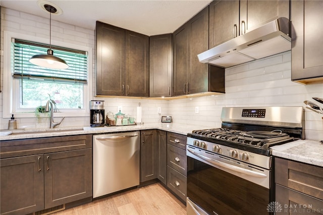 9256 Amchar Ct, Dayton, OH 45458 - kitchen featuring stainless steel appliances, under cabinet range hood, dark brown cabinetry, light wood-style floors, and decorative backsplash