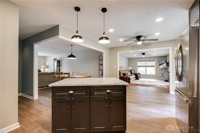 9256 Amchar Ct, Dayton, OH 45458 - kitchen featuring freestanding refrigerator, open floor plan, a textured ceiling, a ceiling fan, and dark brown cabinetry