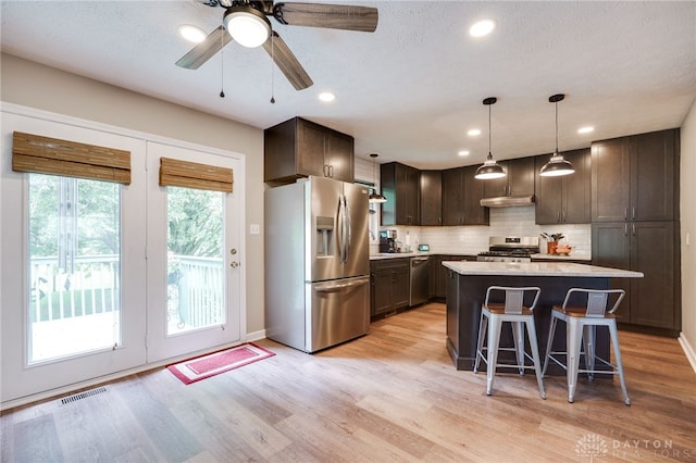 9256 Amchar Ct, Dayton, OH 45458 - kitchen with appliances with stainless steel finishes, dark brown cabinets, tasteful backsplash, a breakfast bar area, and a kitchen island