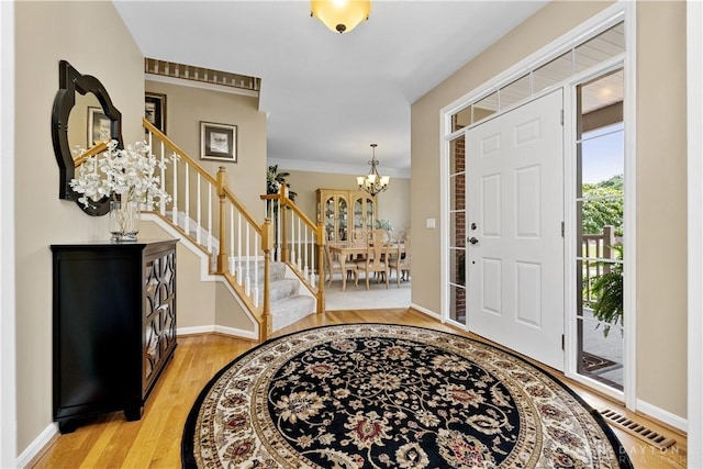1027 W Bridlepath Ln, Miami Twp, OH 45140 - entryway featuring stairs, a chandelier, and light wood-style flooring
