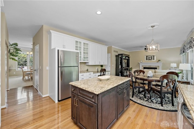 1027 W Bridlepath Ln, Miami Twp, OH 45140 - kitchen featuring stainless steel appliances, dark brown cabinetry, white cabinets, light wood-type flooring, and glass insert cabinets