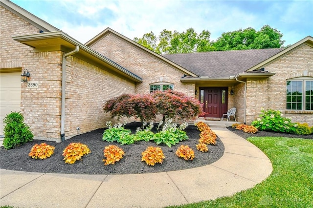2690 Langtree Ln, Washington Twp, OH 45458 - entrance to property with brick siding, an attached garage, and roof with shingles