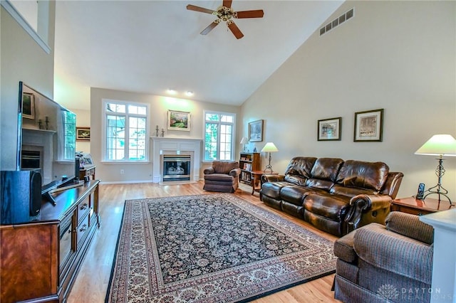 2690 Langtree Ln, Washington Twp, OH 45458 - living area with a glass covered fireplace, ceiling fan, wood finished floors, and high vaulted ceiling