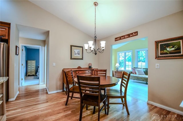 2690 Langtree Ln, Washington Twp, OH 45458 - dining area with light wood-style floors, a chandelier, and vaulted ceiling