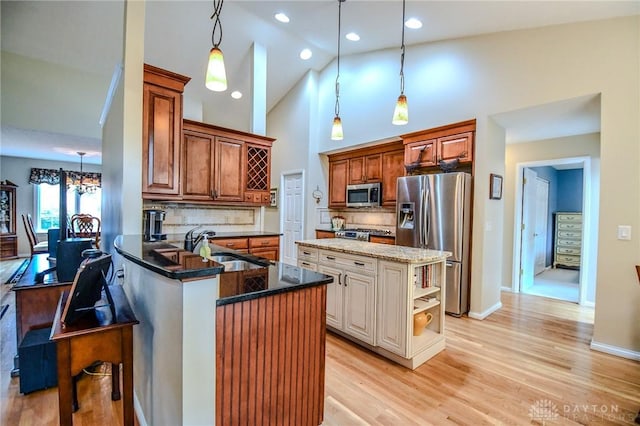 2690 Langtree Ln, Washington Twp, OH 45458 - kitchen featuring appliances with stainless steel finishes, high vaulted ceiling, dark stone countertops, tasteful backsplash, and a peninsula