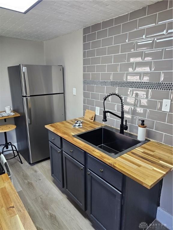 904 Crawford St, Middletown, OH 45044 - kitchen with wooden counters, freestanding refrigerator, tasteful backsplash, and light wood finished floors