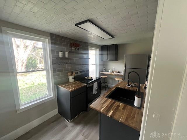 904 Crawford St, Middletown, OH 45044 - kitchen featuring electric range, wooden counters, refrigerator, light wood-style flooring, and an office area