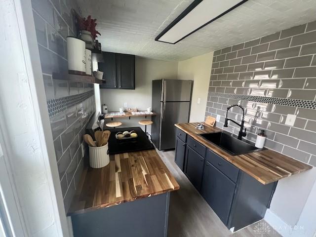 904 Crawford St, Middletown, OH 45044 - kitchen with freestanding refrigerator, wood counters, wood finished floors, and tasteful backsplash