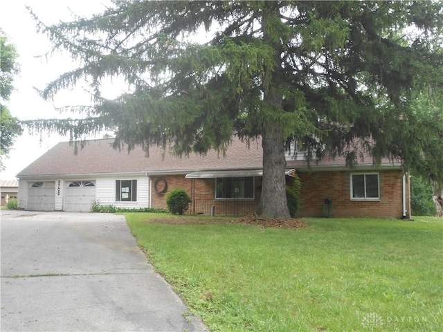 9705 E Haskett Ln, Bethel Twp, OH 45424 - ranch-style home featuring an attached garage, a front yard, driveway, and brick siding