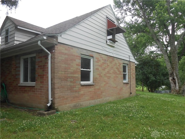 9705 E Haskett Ln, Bethel Twp, OH 45424 - view of property exterior with brick siding, a yard, and roof with shingles