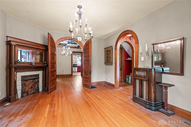 2311 S Dixie Dr, Kettering, OH 45409 - dining space with a chandelier, arched walkways, light wood finished floors, and a fireplace