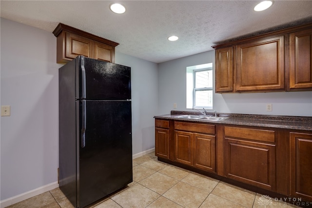1717 Pershing Ave, Middletown, OH 45044 - kitchen featuring freestanding refrigerator, dark countertops, recessed lighting, light tile patterned flooring, and a textured ceiling