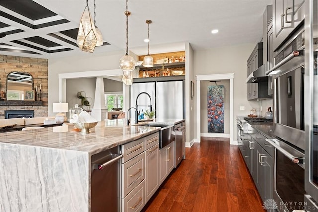 79 White Beech Ct, Springboro, OH 45066 - kitchen featuring open floor plan, light stone countertops, dark wood-type flooring, a stone fireplace, and a spacious island
