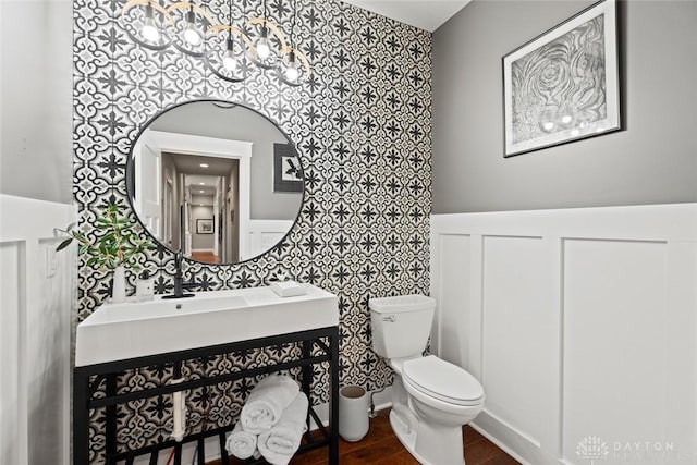 79 White Beech Ct, Springboro, OH 45066 - half bathroom featuring wallpapered walls, vanity, a chandelier, wainscoting, and wood finished floors