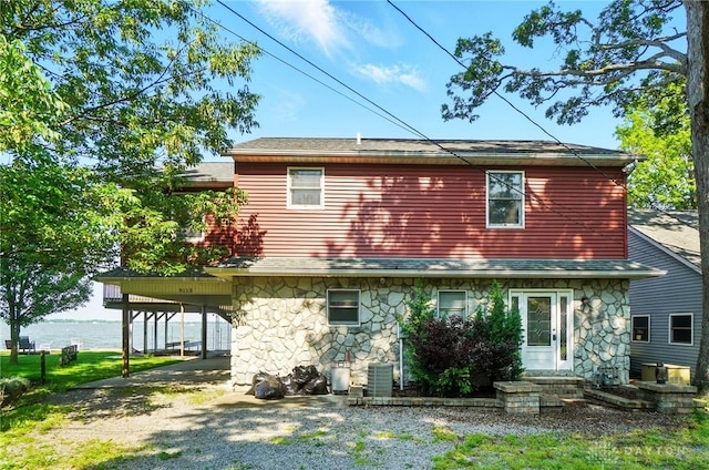 9113 Maple St, Huntsville, OH 43324 - back of property with stone siding, driveway, and a carport