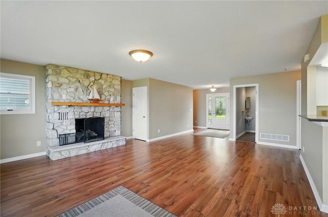 9113 Maple St, Huntsville, OH 43324 - unfurnished living room featuring wood finished floors and a stone fireplace
