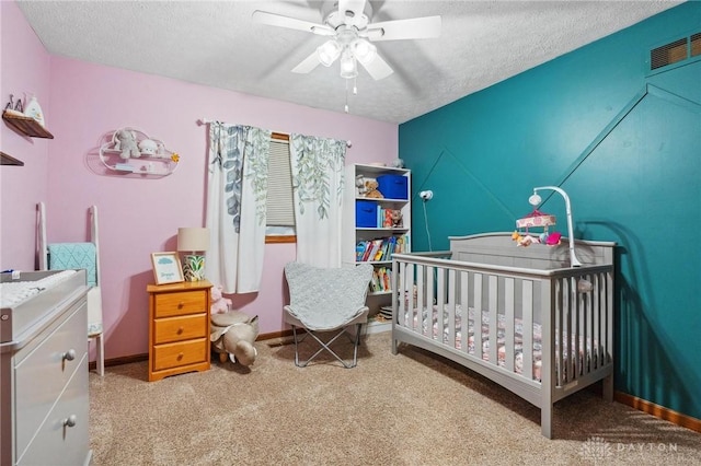923 Lewis Creek Ct, Xenia, OH 45385 - bedroom with a nursery area, carpet floors, a textured ceiling, and ceiling fan