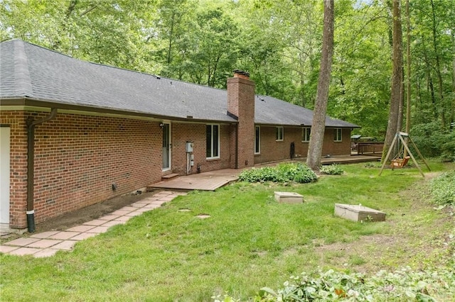 923 Lewis Creek Ct, Xenia, OH 45385 - back of house featuring a chimney, brick siding, a wooden deck, a yard, and roof with shingles