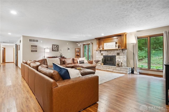 923 Lewis Creek Ct, Xenia, OH 45385 - living room with plenty of natural light, light wood finished floors, a fireplace, recessed lighting, and a textured ceiling
