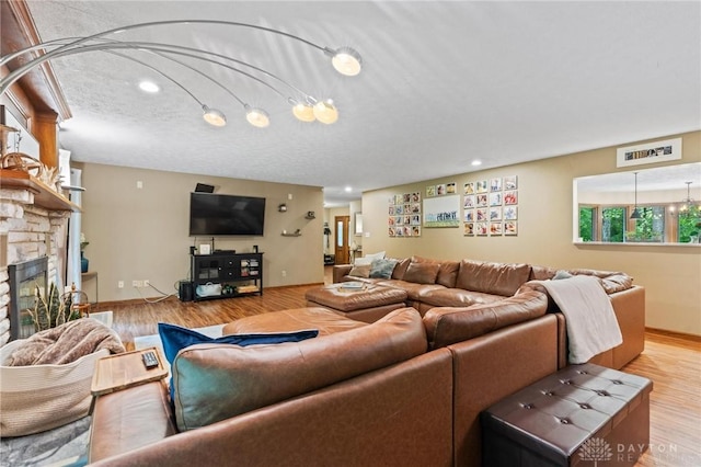 923 Lewis Creek Ct, Xenia, OH 45385 - living area featuring wood finished floors, a stone fireplace, and recessed lighting