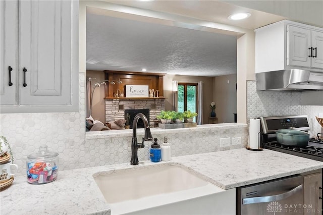 923 Lewis Creek Ct, Xenia, OH 45385 - kitchen with stainless steel appliances, wall chimney exhaust hood, backsplash, and a fireplace