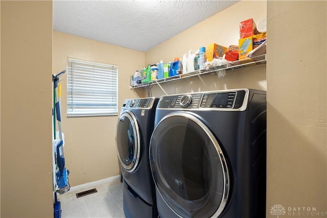 12052 Doe Run Ct, Springfield Twp, OH 45240 - laundry area with washing machine and clothes dryer, a textured ceiling, and tile patterned flooring