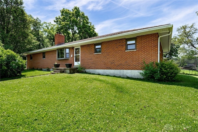 4675 Dearth Rd, Franklin Twp, OH 45005 - rear view of house with a chimney, brick siding, and a lawn
