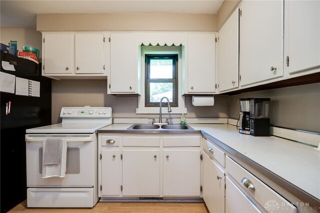 4675 Dearth Rd, Franklin Twp, OH 45005 - kitchen with electric range, light countertops, white cabinetry, and freestanding refrigerator