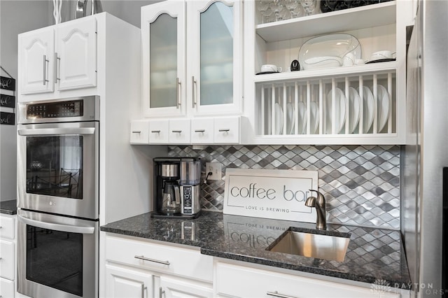 440 David Ln, Mason, OH 45040 - kitchen featuring stainless steel double oven, dark stone countertops, white cabinets, and backsplash