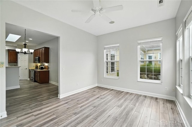 10101 Sawtry Ln, Washington Twp, OH 45458 - unfurnished living room featuring wood finished floors, a chandelier, plenty of natural light, and ceiling fan