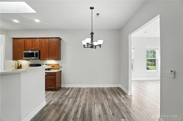 10101 Sawtry Ln, Washington Twp, OH 45458 - kitchen featuring stainless steel microwave, recessed lighting, wood finished floors, a chandelier, and light countertops