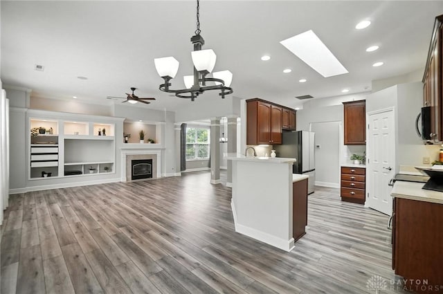 10101 Sawtry Ln, Washington Twp, OH 45458 - kitchen featuring freestanding refrigerator, light wood finished floors, light countertops, recessed lighting, and a glass covered fireplace