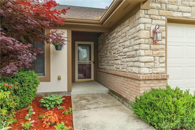 797 Waldsmith Way, Vandalia, OH 45377 - doorway to property featuring stone siding, a shingled roof, and an attached garage